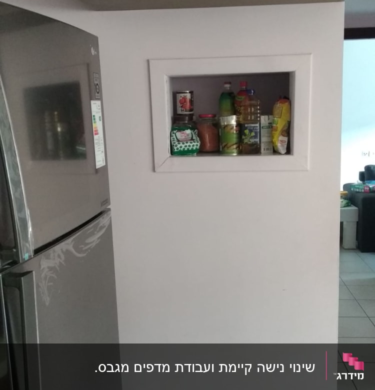 מוצרים על מדף גבס במטבח, כולל בקבוקים וצנצנות